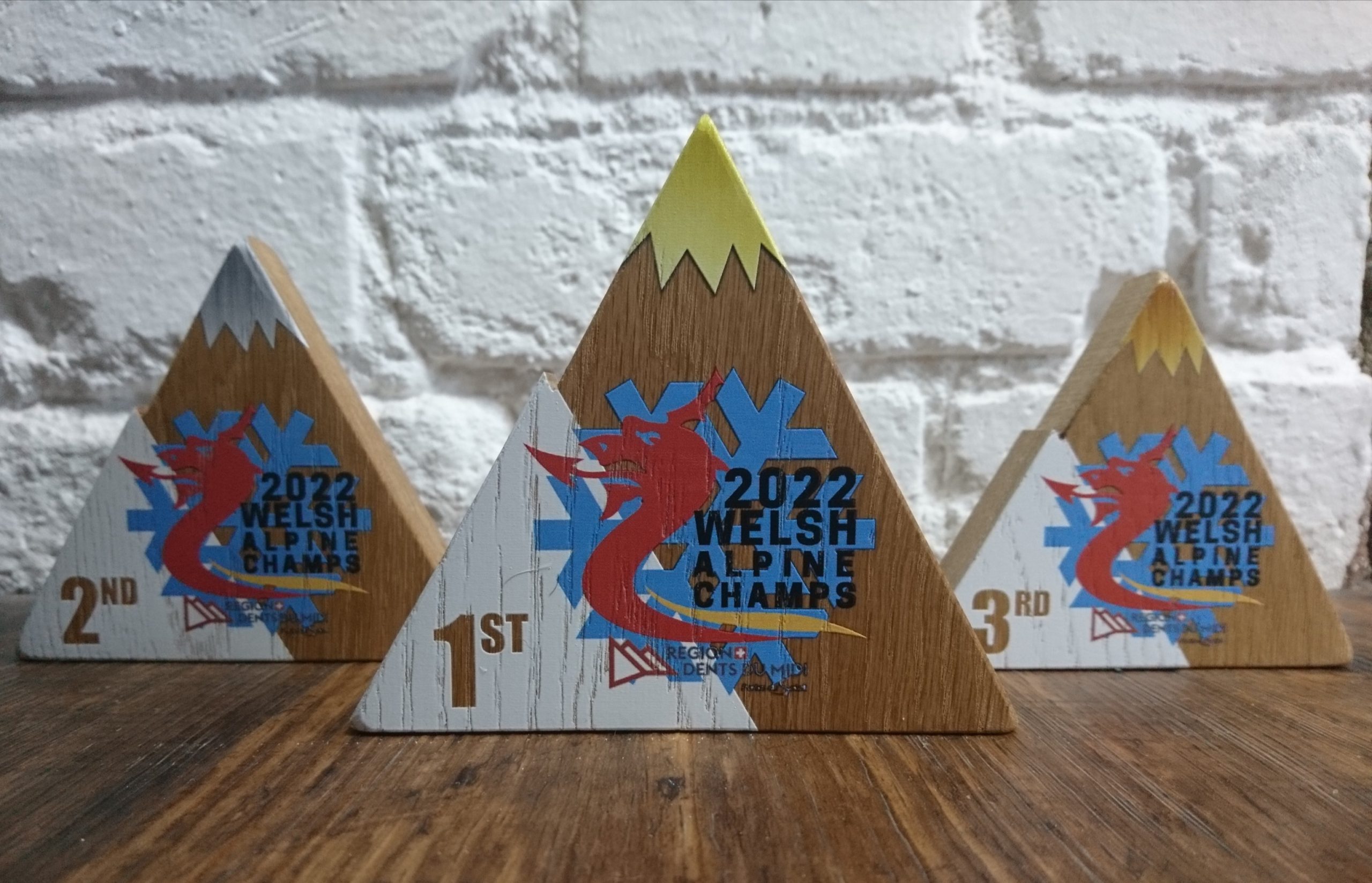 Snow Sport Wales trophies in 1st, 2nd and 3rd place styles made from Oak and shaped like mountains. Printed in colour